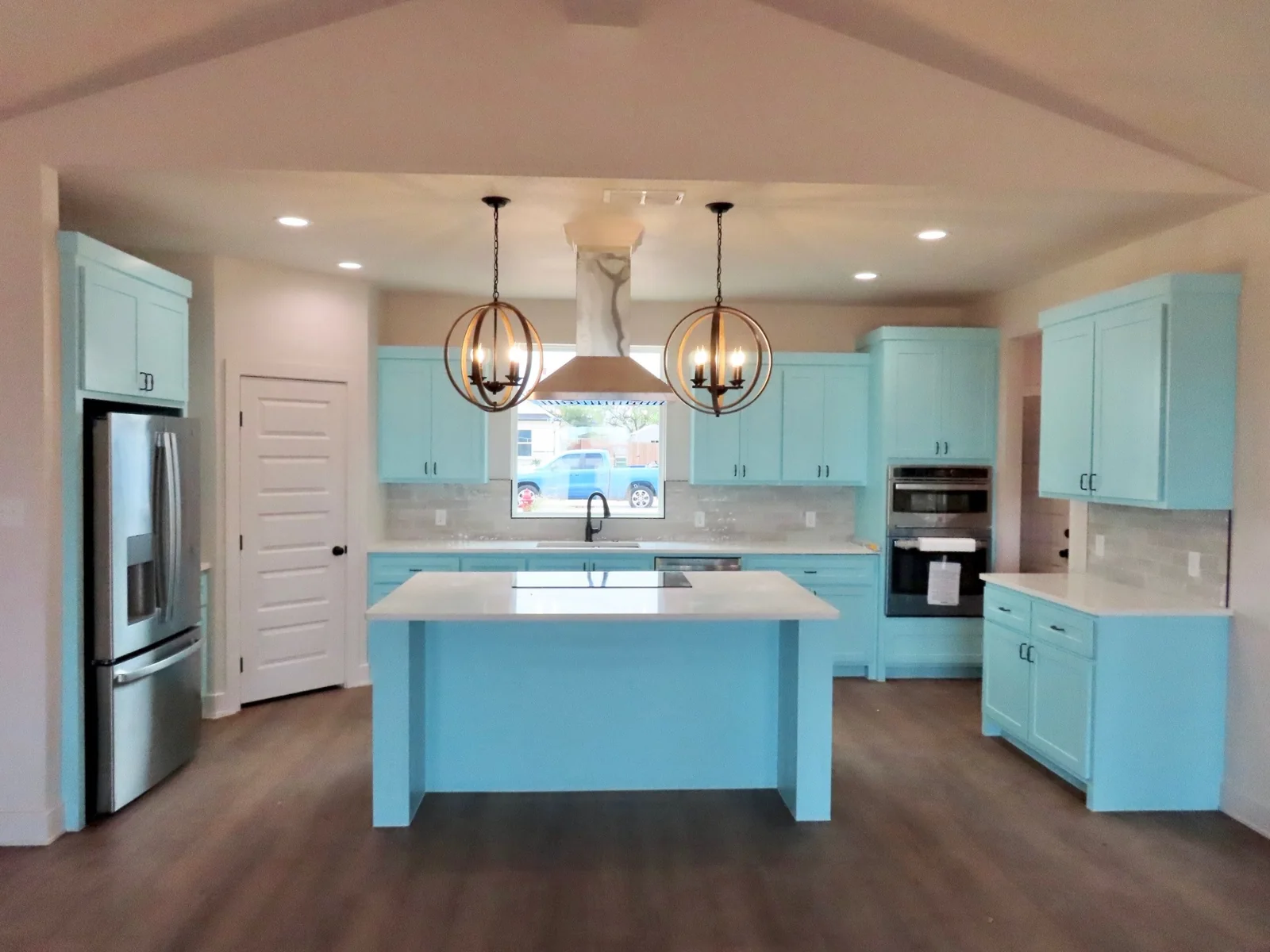 Turquoise kitchen cabinets and island with white counters
